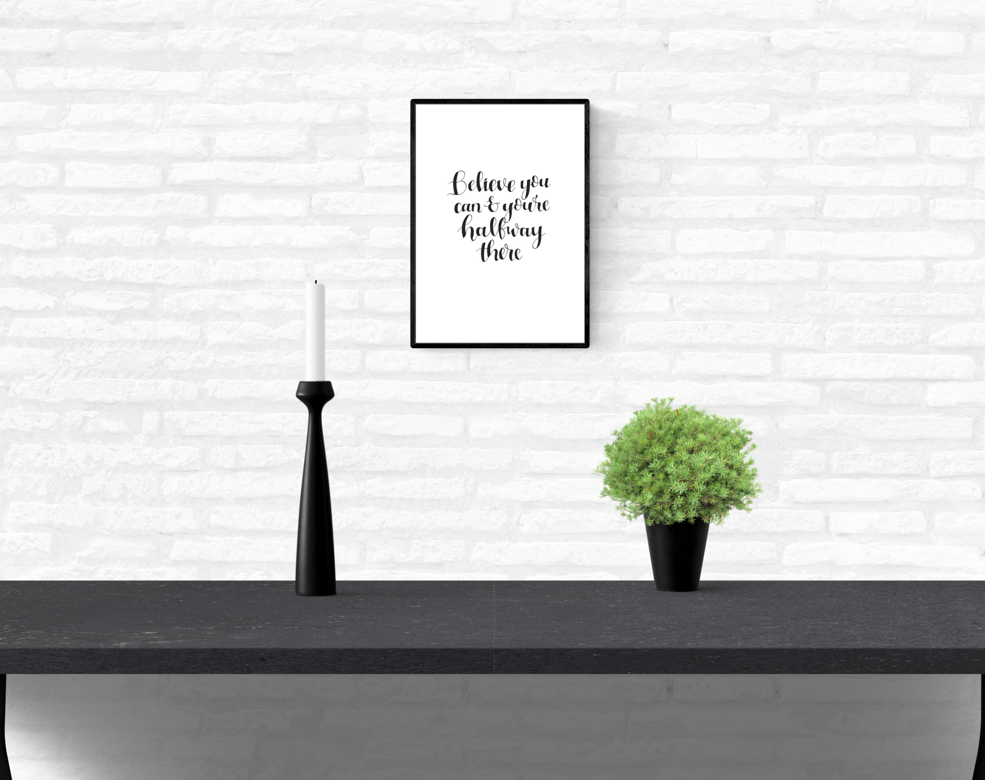 A white, brick home dining room wall with a hung, framed quote print with the words, “Believe You Can And You’re Halfway There”