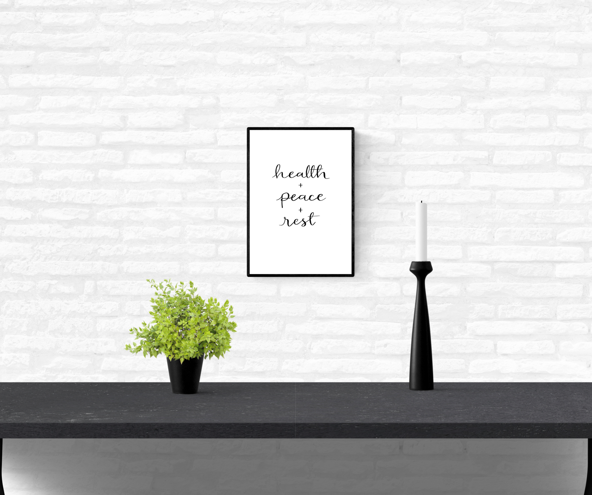 Framed and mounted wall quote print on an interior white brick wall with the words “health + peace + rest”