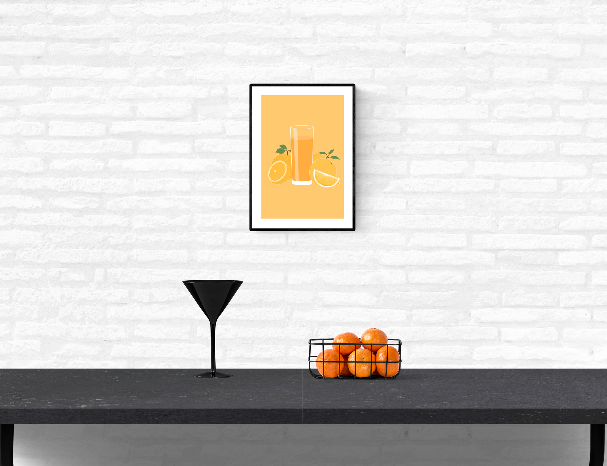 Framed wall art print of a tall cold glass of orange juice with orange fruits surrounding the glass mounted on a home’s interior white brick wall